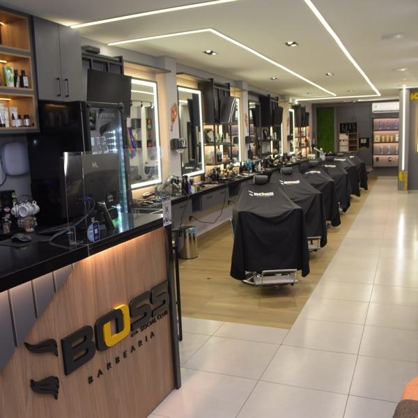 Balcão de recepção moderno com letreiro iluminado da BOSS Barbearia