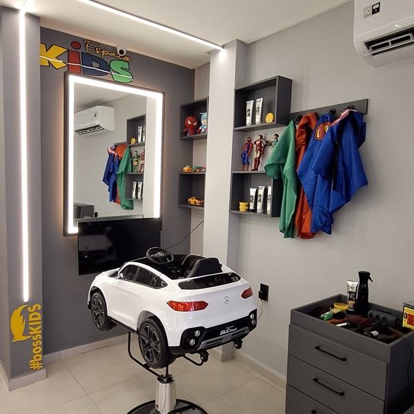 Espaço Kids da BOSS com cadeira em formato de carro vermelho e capas de super-heróis